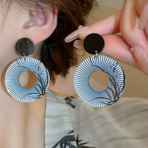 Detail showing vintage bamboo pattern on grey-blue and black acrylic hoop earrings