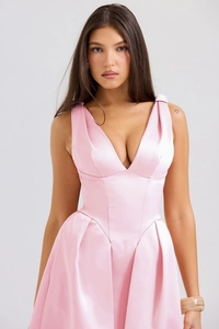 Détail d'une robe longue en satin rose avec col en V profond et jupe plissée élégante