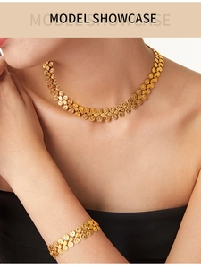 Detail of gold-tone necklace and bracelet set featuring intricate sunburst metal patterns