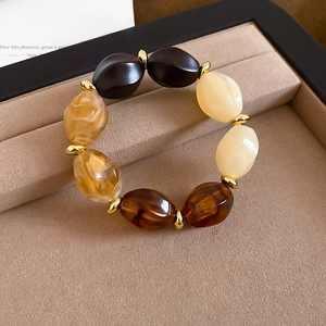 Close-up of vintage acrylic beaded bracelet with golden spacers in luxury display box