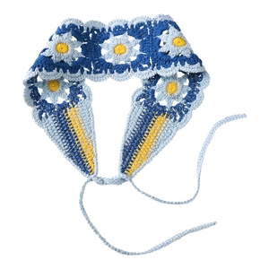 Detail of hand-crocheted daisy headband showing intricate floral knit and blue-white texture