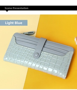Detail of light blue crocodile embossed leather wallet with multiple card slots and snap