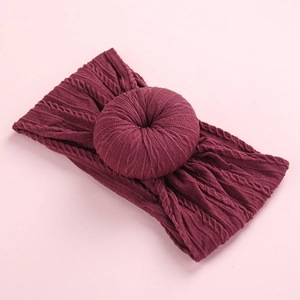 Detailed texture of burgundy knitted nylon baby headband with a decorative doughnut knot