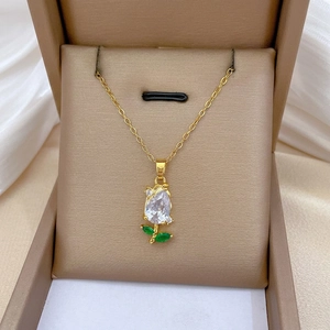 Elegant gold tulip pendant necklace with clear and green crystals in a gift box