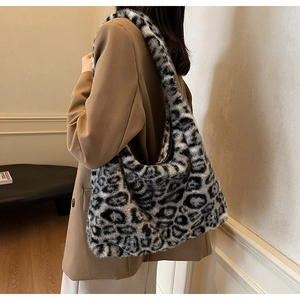 Détail d'un sac cabas en fausse fourrure léopard porté avec un tailleur beige chic