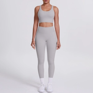 Détail d'un ensemble de yoga gris deux pièces avec brassière croisée et legging taille haute