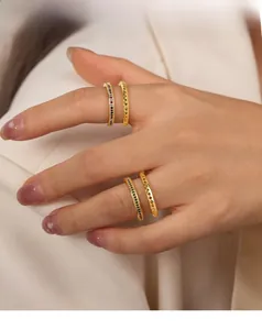 Close-up of gold layered rings with colorful zircon inlay and geometric texture patterns