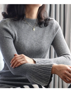 Detail view of gold letter pendant necklace styled on grey ribbed knit flare sleeve top