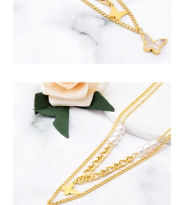 Close-up of golden double-layer necklace with shell butterfly pendant and pearls