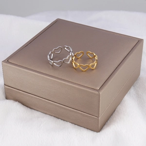 Minimalist heart cutout open rings in silver and gold finish on a jewelry box