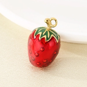 Macro shot of strawberry charm with red enamel finish and gold-tone metal loop