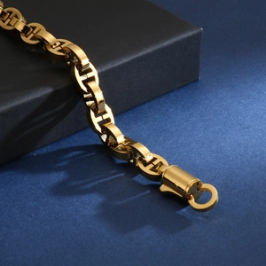 Macro shot of gold stainless steel anchor link chain bracelet with cylindrical clasp