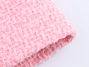 Detailaufnahme von rosa Tweed-Stoff mit feiner Webstruktur und hochwertigen Fasern
