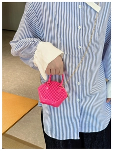 Detail shot of mini pink shell bag with woven texture and elegant golden chain strap