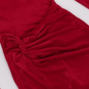 Close-up of the elegant velvet fabric featuring a knotted design on the red evening dress