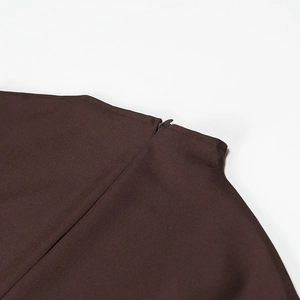 Detail of mock neck dress with hidden back zipper on dark brown high-quality fabric