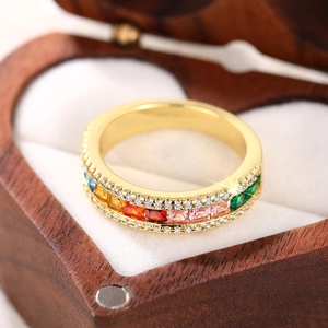 Macro view of golden ring with colorful rainbow square gemstones and micro-pave white diamonds