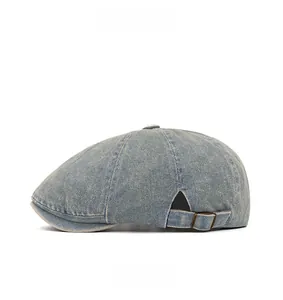 Side view of light blue washed denim beret cap featuring vintage metal side buckles