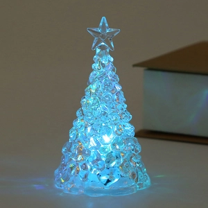 Close-up of a glowing blue LED crystal Christmas tree candle lamp with star topper