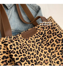 Détail du sac cabas léopard avec bandoulière en cuir marron et logo de marque embossé