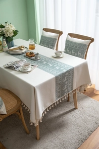 Detail of Christmas reindeer jacquard tablecloth with elegant fringe tassels and matching cushion