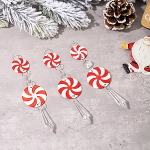 Close-up of red and white spiral candy icicle ornaments with pine cones on festive background