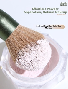 Macro shot of fluffy powder brush head capturing fine loose powder for flawless makeup application