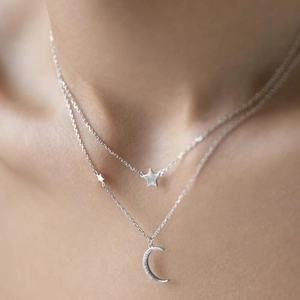 Detailed view of layered S925 silver necklace with sparkling moon and star pendants