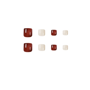 Glossy amber burgundy and cream press-on toenails set against a clean white background
