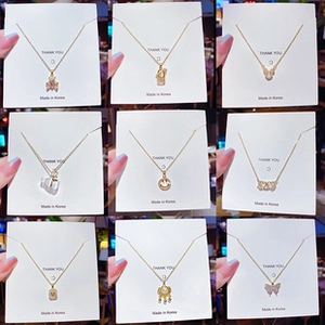 Detailed grid view of nine assorted gold-plated titanium necklaces with various charms