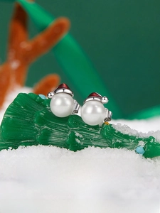 Macro view of Christmas snowman pearl stud earrings with a red hat on s925 silver base