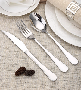 Three-piece stainless steel cutlery set with knife, fork and spoon on a woven placemat