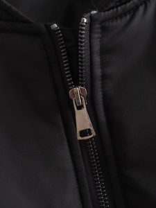 Close-up of durable silver metal zipper on black bomber jacket made of polyester fabric