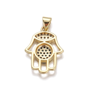 Macro view showing the detailed back of a gold-plated Hamsa hand charm with dark stones