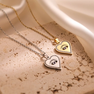 Gold and silver evil eye heart necklaces with cubic zirconia on a porous stone and silk
