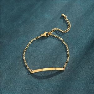 Detailed view of a gold curved bar bracelet on a dark green velvet texture backdrop