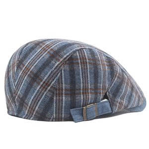 Close-up of retro plaid flat cap featuring adjustable denim strap and bronze metal buckle