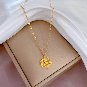 Polished hollow maple leaf pendant necklace in titanium steel on champagne jewelry box