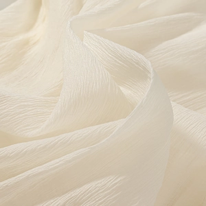 Macro detail of textured white pleated fabric with elegant layered ruffles on a dress