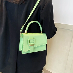 Minimalist mint green PU leather small square bag with decorative buckle on black suit