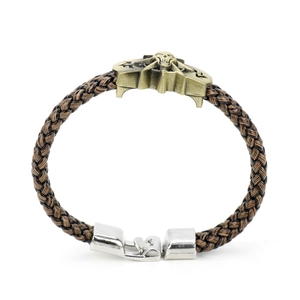 Detail of a brown braided rope bracelet featuring an antique bronze skull and silver clasp