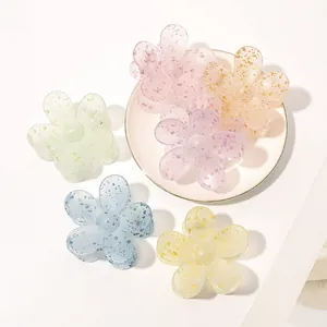 Close-up of matte floral hair claws in pastel colors with speckled acrylic texture