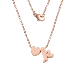 Detail of rose gold heart pendant with cursive letter K on a fine link chain necklace