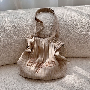 Detailed view of the striped canvas tote bag with Bonjour embroidery and drawstring feature