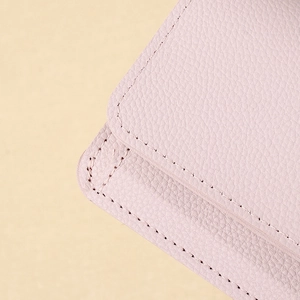 Dettaglio del portafoglio rosa in pelle grana litchi con cuciture precise e morbide