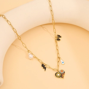 Golden link chain necklace with pearl, evil eye, and floral heart charms on a beige stand