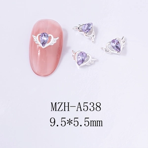 Macro detail of purple heart nail charm with silver wings on pink nail model