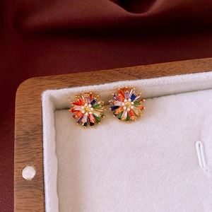 Macro detail of sparkling flower stud earrings with colorful zircon in a velvet jewelry box