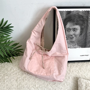 Detailed view of pink corduroy tote bag featuring a bow tie and spacious outer pocket
