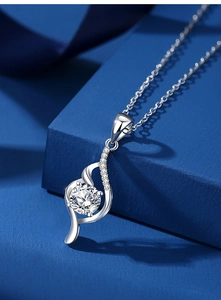 Macro shot of 1 carat round moissanite pendant with elegant silver wave setting